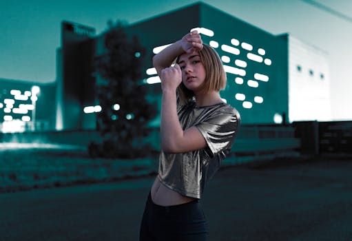 黄昏时分，一位身穿金属上衣的时尚女性在现代城市中自信地摆姿