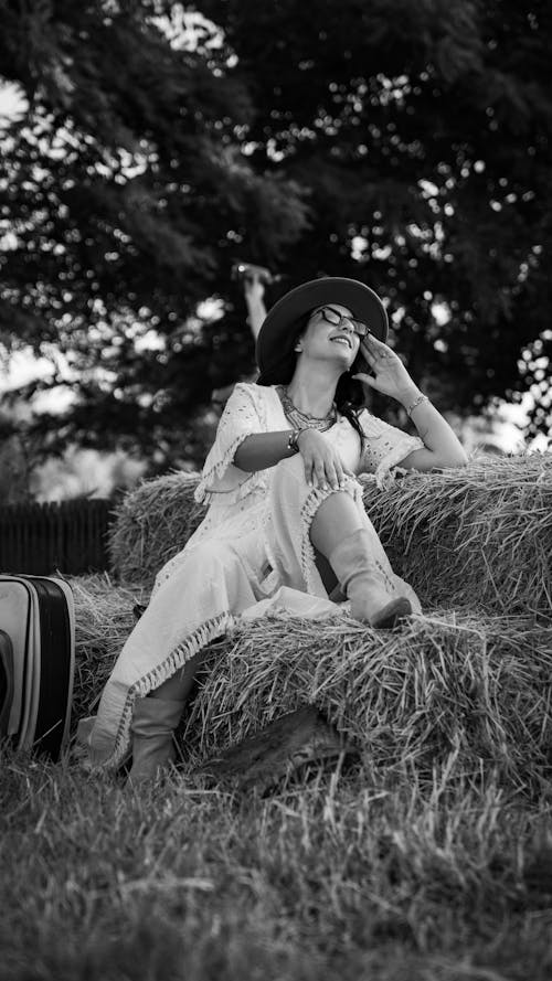 Woman in Dress Sitting on Hay Bale