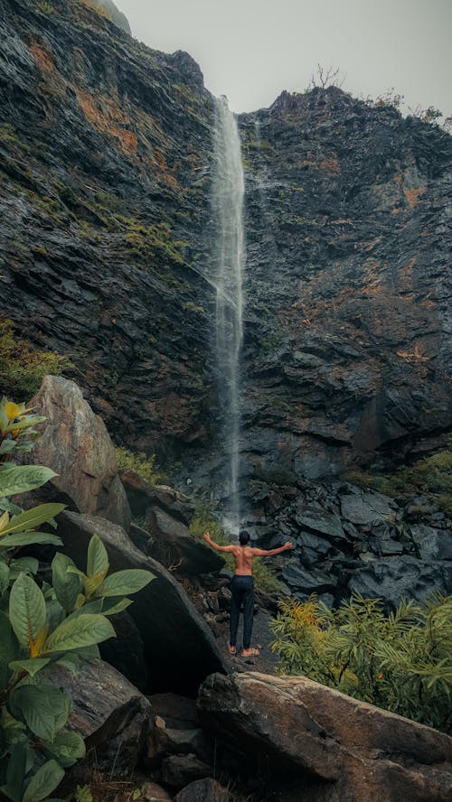 Shirtless Man by Waterfall