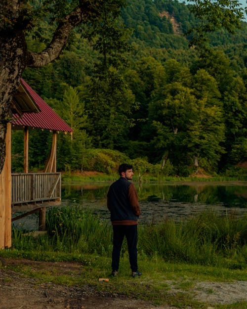 Man by Cottage by Lake