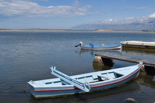 Serene view of boats moored in Nin Harbor, Croatia with mountains in the background.