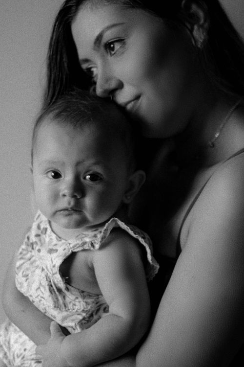 Free Intimate black and white portrait of a mother lovingly holding her baby. Stock Photo