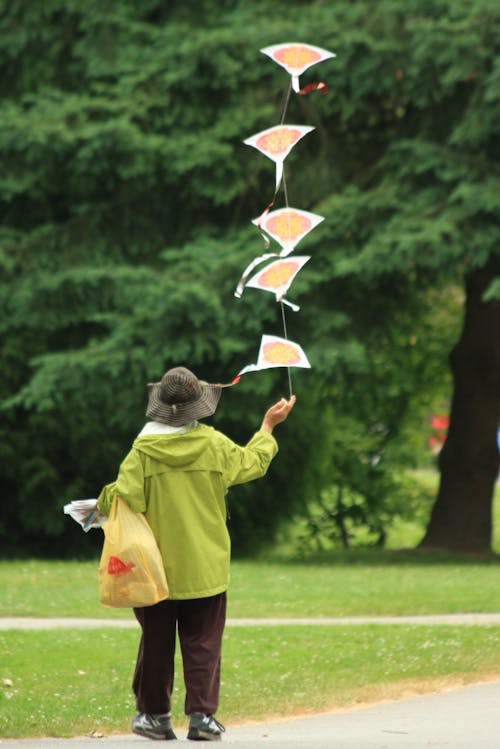 Person Launching Several Small Kites in a Park