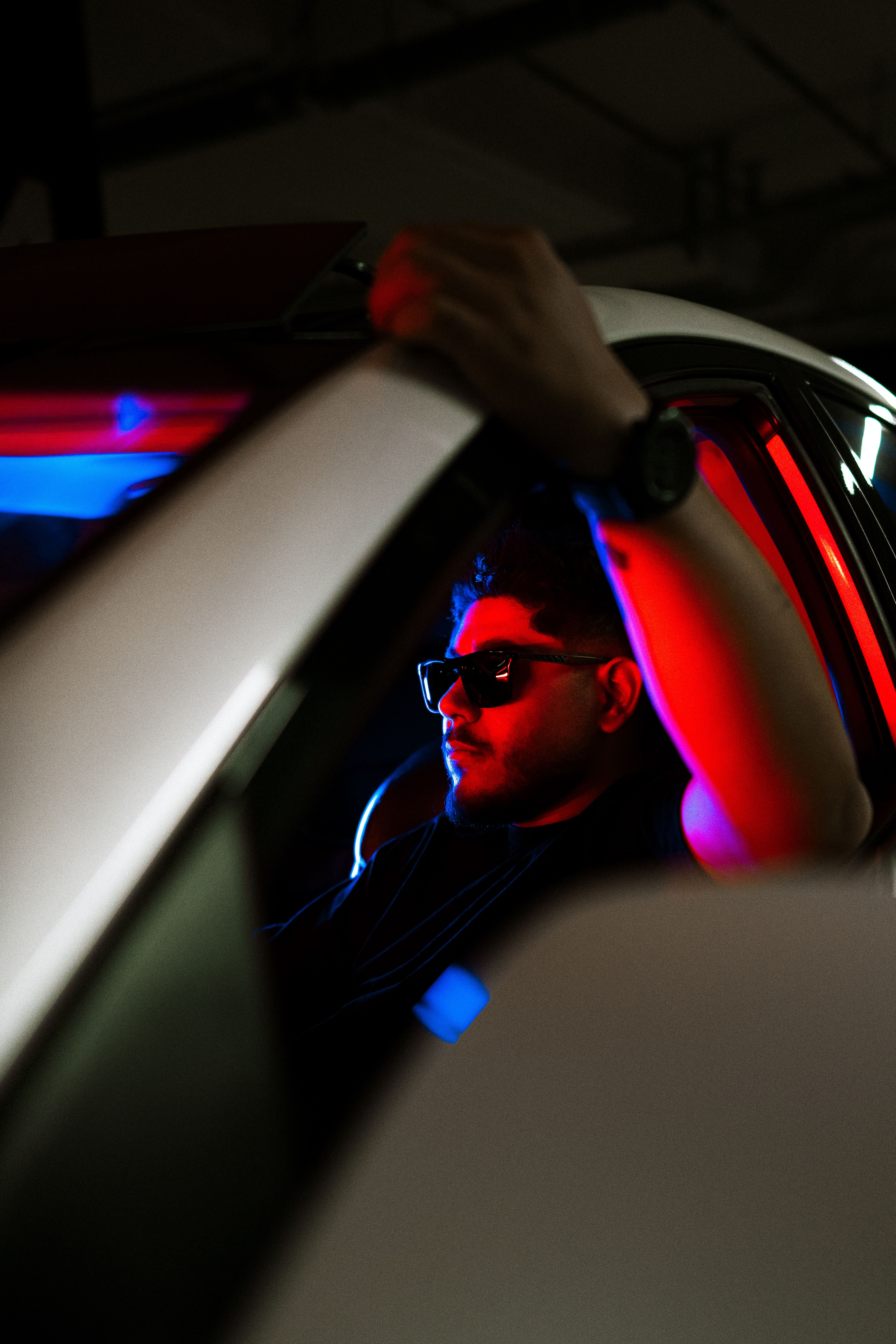Young Man Sitting in a Car with Red Lighting · Free Stock Photo