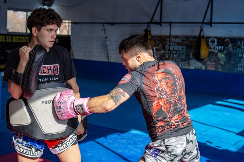 Training with focus mitts in a bright gym