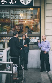 Three men interacting outside a Chinatown restaurant in Toronto, capturing urban street life.