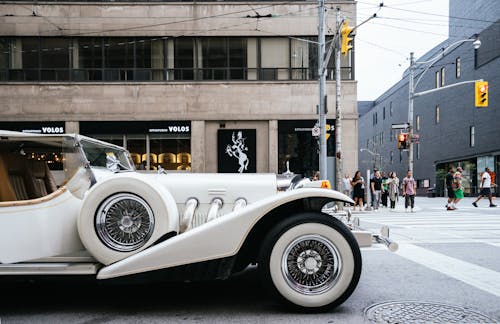 White Vehicle Near Gray Lamp Post and Brown Building Structure