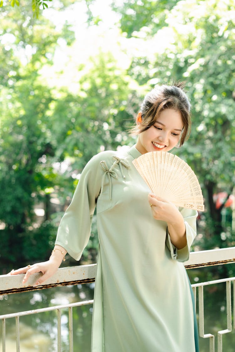 Smiling Woman In Traditional Dress Standing In Summer Park