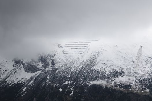 Aerial view of snow-covered mountains in Tux, Tirol, Austria under cloudy skies.