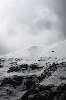 Captivating view of snowy mountain peaks in Hintertux, Austria, under cloudy skies.