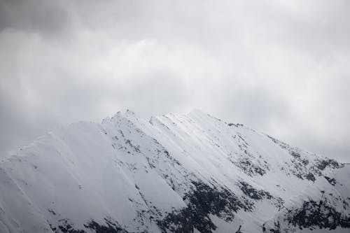 A snow covered mountain with a cloudy sky