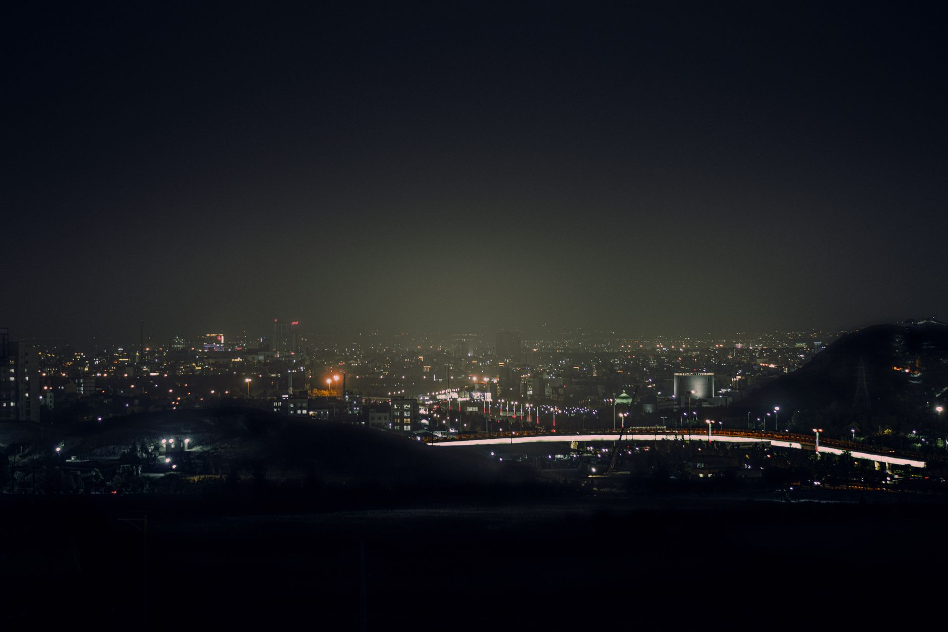 A vibrant aerial view of a city illuminated at night with sparkling lights across the skyline.