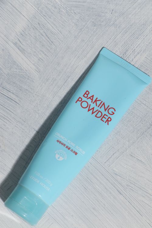 Free Blue baking powder skincare tube against textured background in bright lighting. Stock Photo