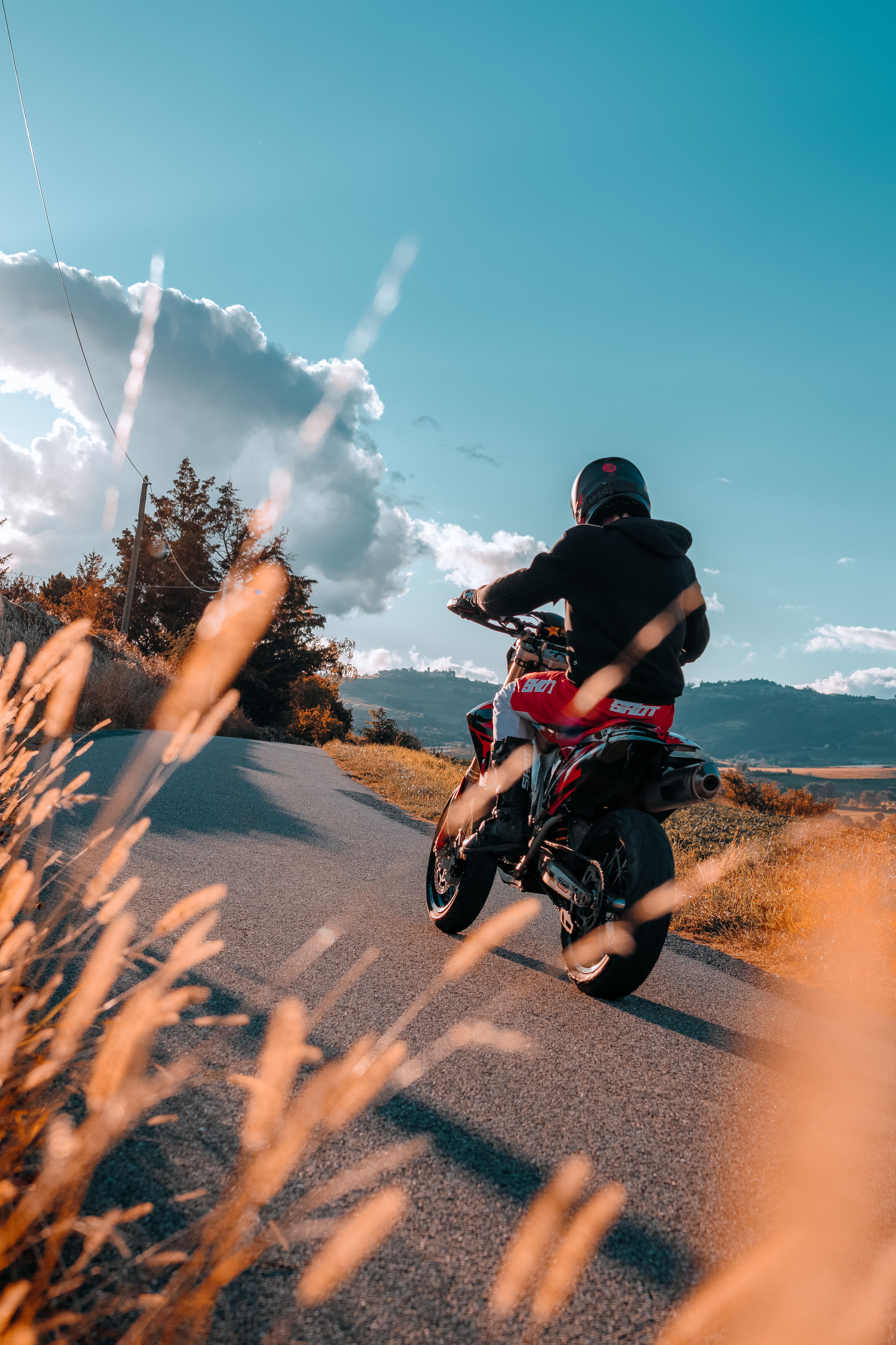 Biker Riding on Motorcycle on Rural Road · Free Stock Photo