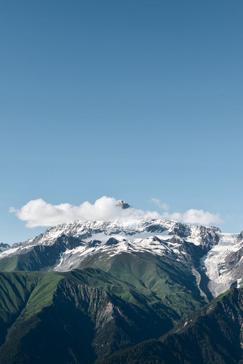 Free Breathtaking view of a snow-capped mountain summit under a clear blue sky, perfect for travel and nature backgrounds. Stock Photo