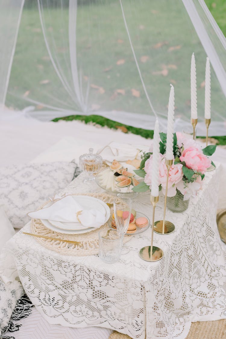 Candles, Flowers And Snacks On A Set Table Standing Under A Translucent Veil