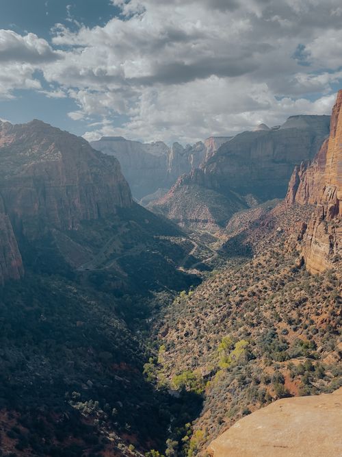 Free Majestic landscape of Zion Canyon with cloudy sky, showcasing rugged mountains and deep valleys. Stock Photo