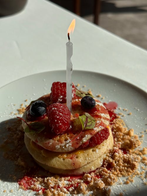 A Candle on Top of Pancakes with Berries 