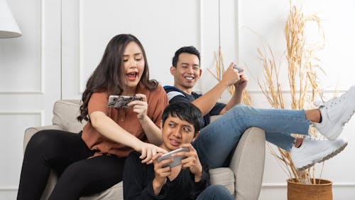 Group of young Asian people sitting and addicted to playing mobile online games together