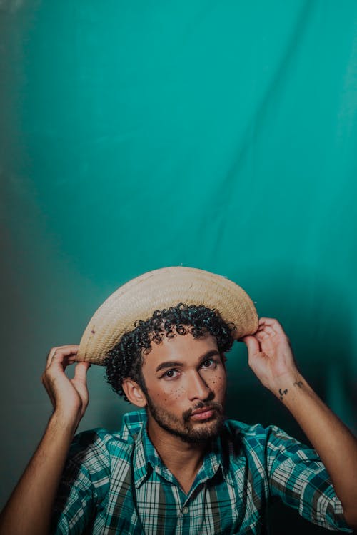 Young Man in a Checkered Shirt and a Hat 