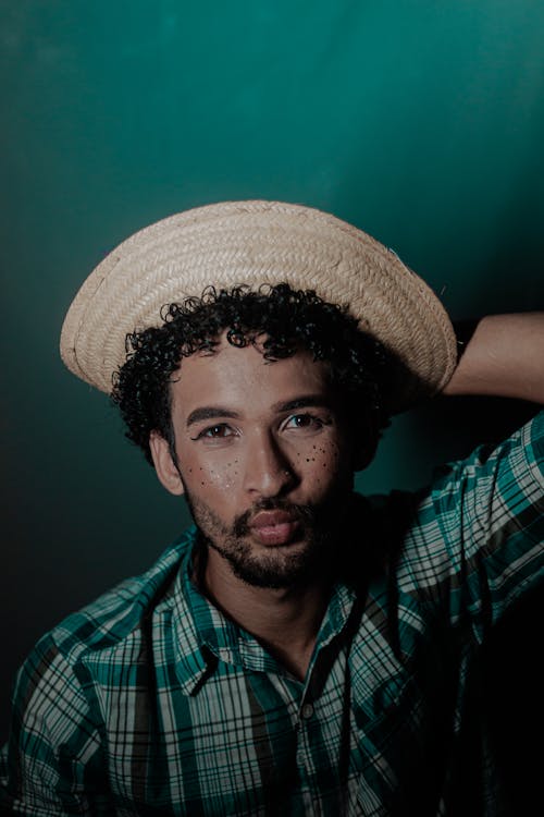 Young Man in a Checkered Shirt and a Hat 