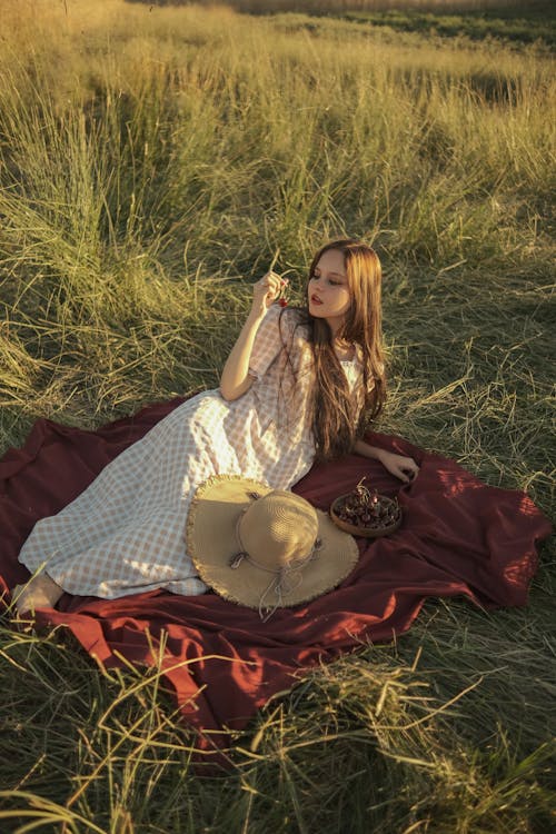 Woman Sitting on Blanket on a Field