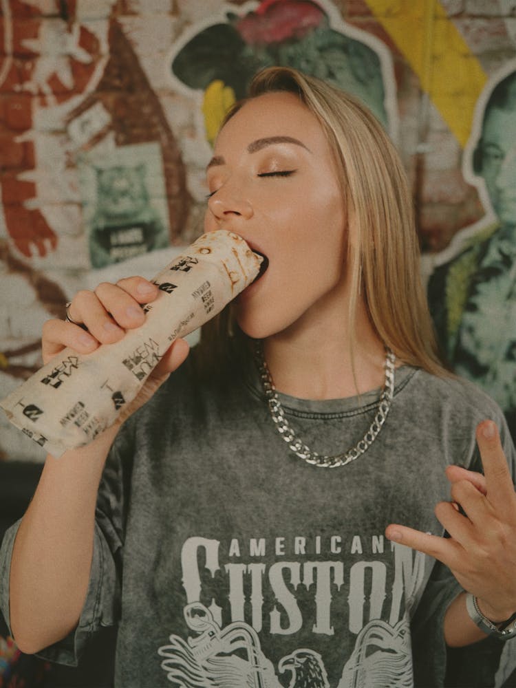 Young Woman Eating A Fast Food Wrap