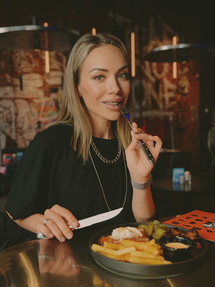 Young Woman Eating A Meal At The Restaurant 