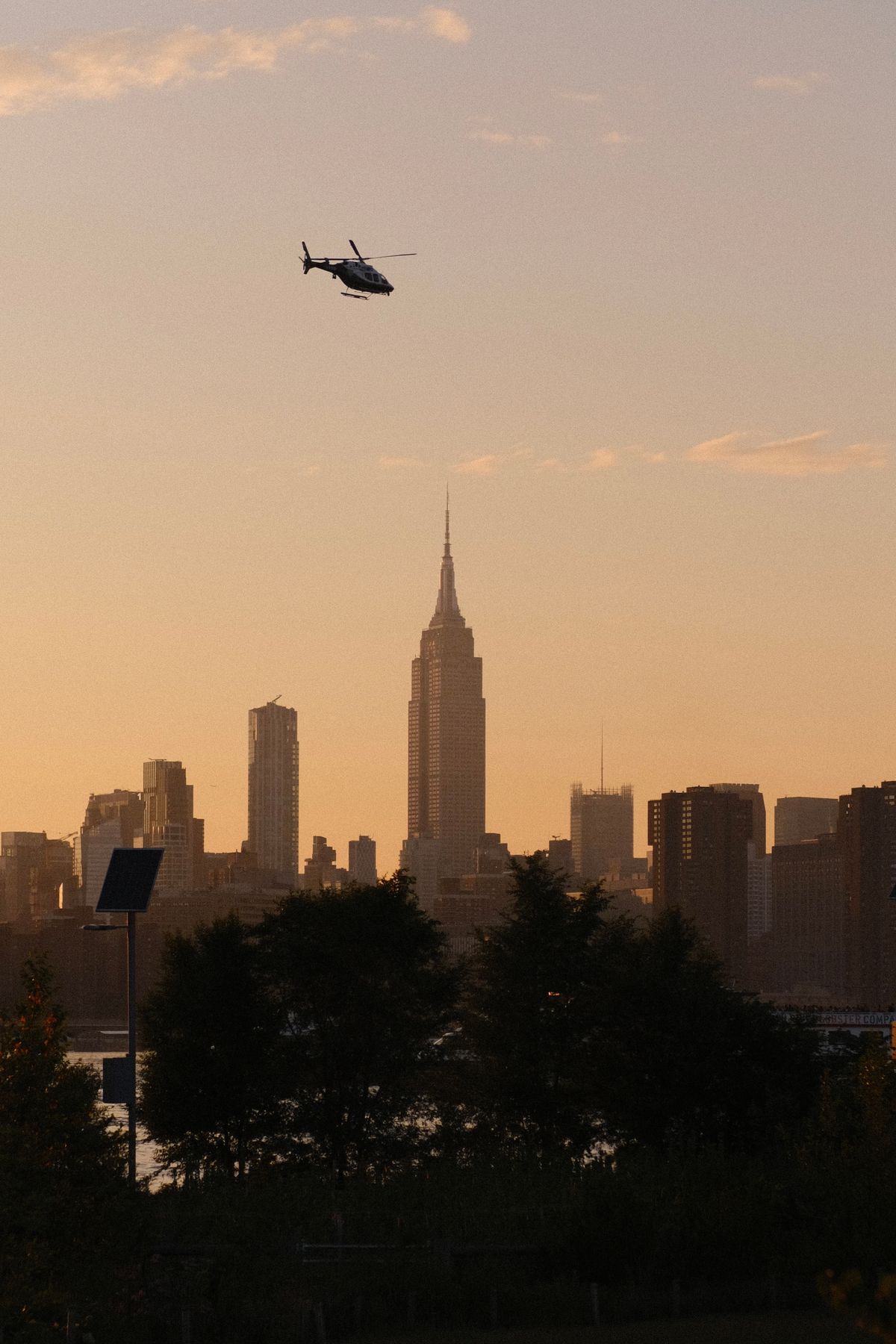 eVTOL air taxi helicopter flying over New York City skyline at dusk