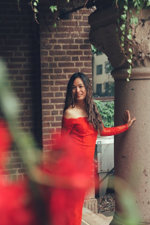 Woman in Red Strapless Dress by Column