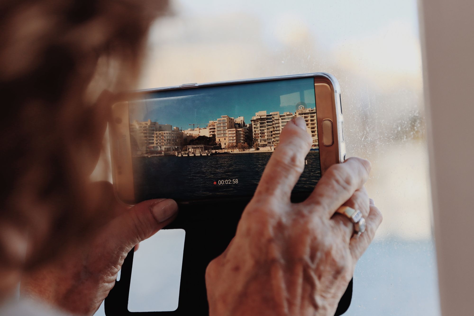 Mano sosteniendo un teléfono con un feed de video vertical en pantalla
