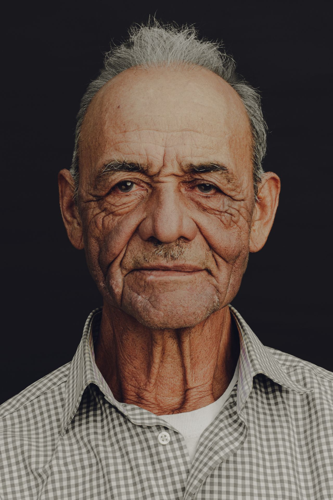 Senior man wearing a checked button shirt with easy closures