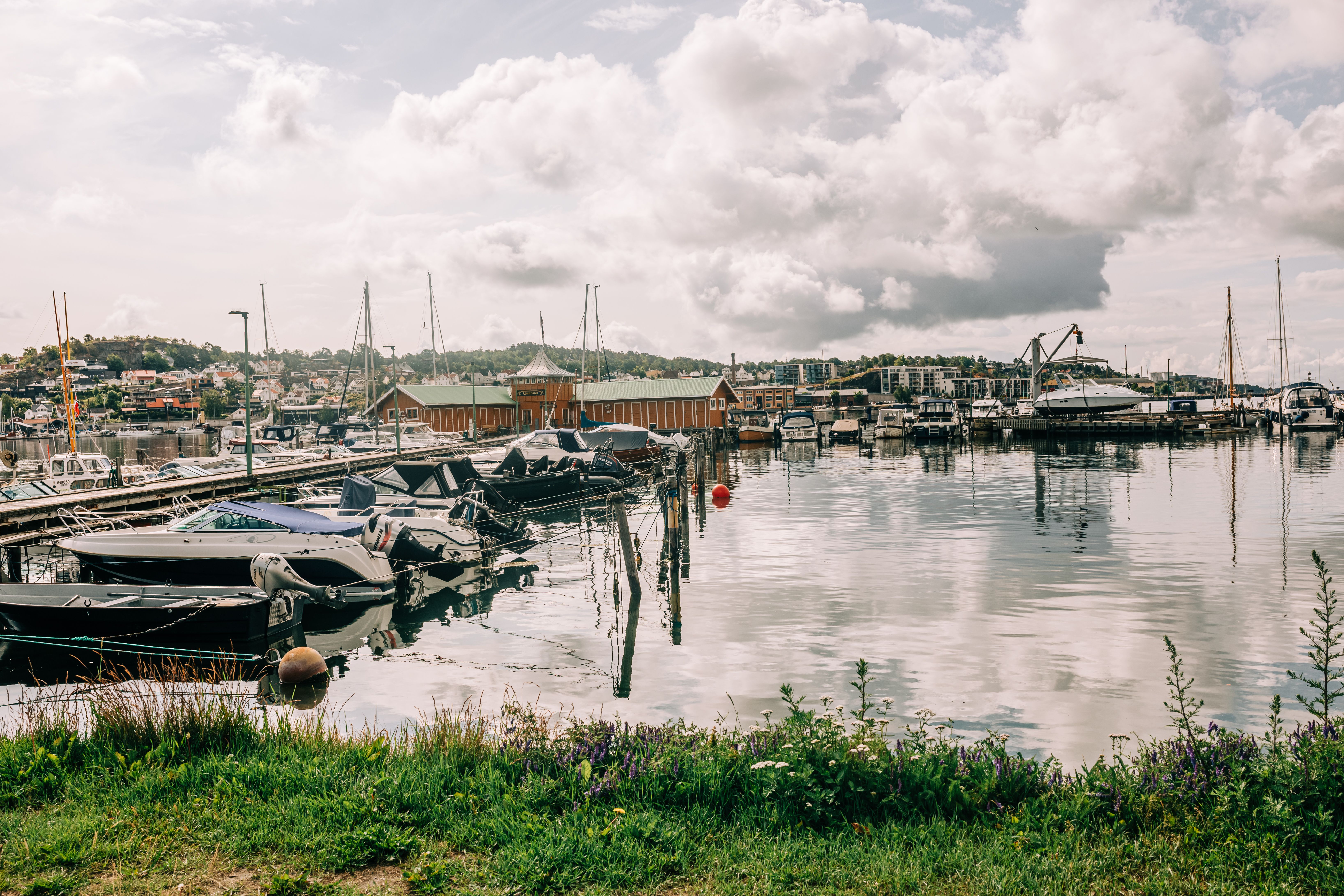 Yacht masts in a small Estonian harbour with a low hotel building along the quay