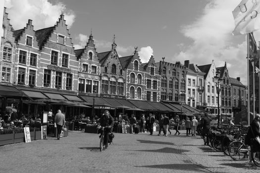Historic square in Bruges with iconic Flemish architecture and bustling city life.