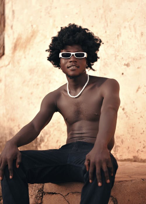 Portrait of a Shirtless Man Wearing Sunglasses and a Pearl Necklace
