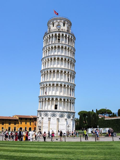 Free Capture of the Leaning Tower of Pisa, a famous landmark in sunny Italy, surrounded by tourists. Stock Photo