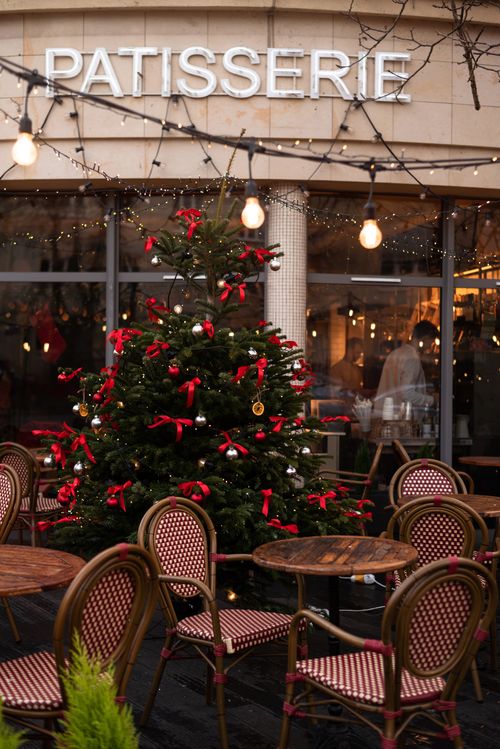 Free Cozy outdoor patisserie with festive Christmas tree and vintage chairs in Warsaw. Stock Photo