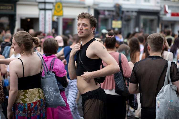 Crowd Of People During A Pride Festival With A Young Man In The Foreground