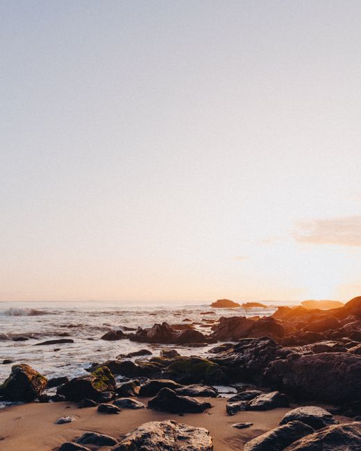 Captivating sunset over rocky beach at Balneário Camboriú, Brazil.