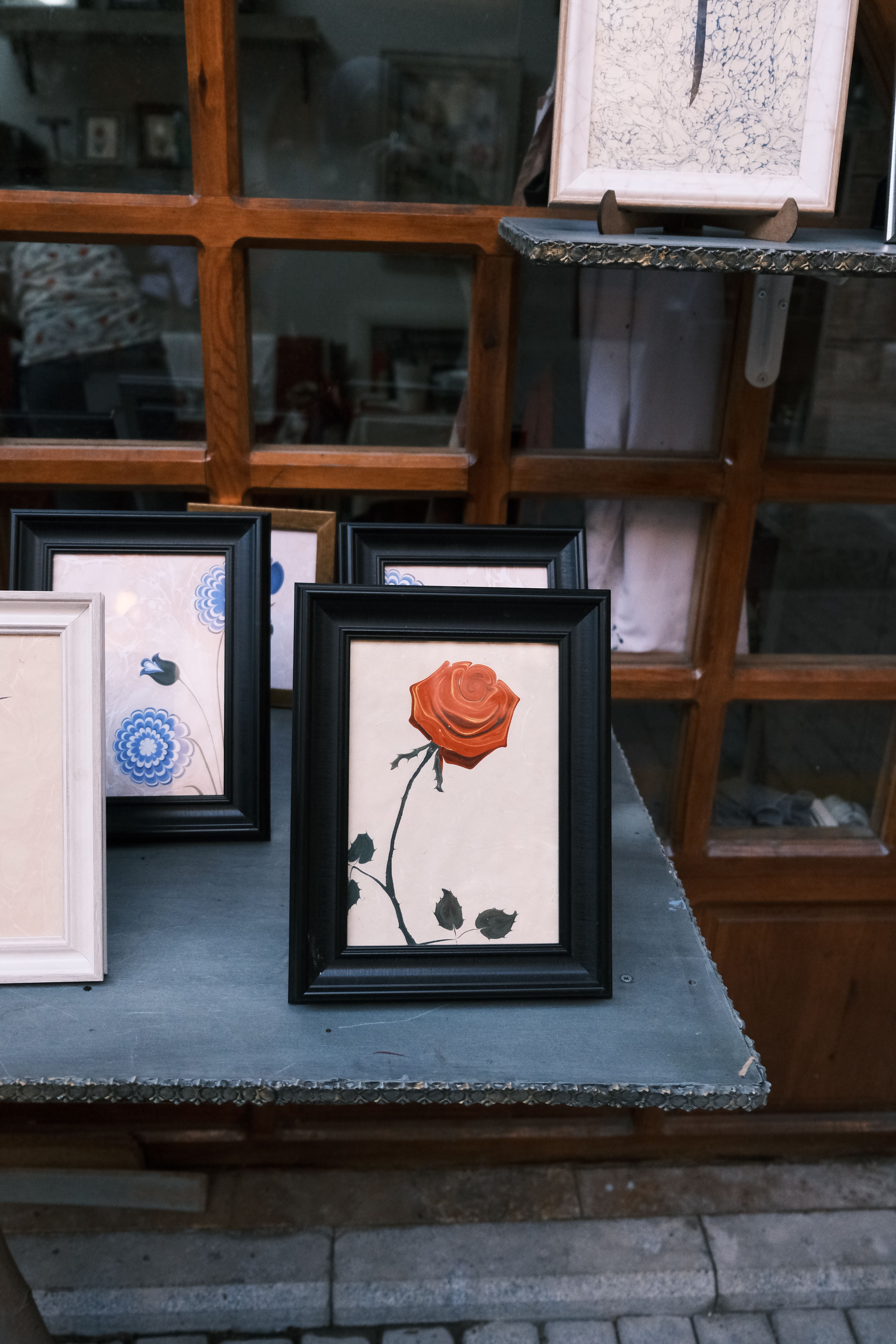 Close-up of framed floral artwork on a rustic table, creating a charming decor setting.