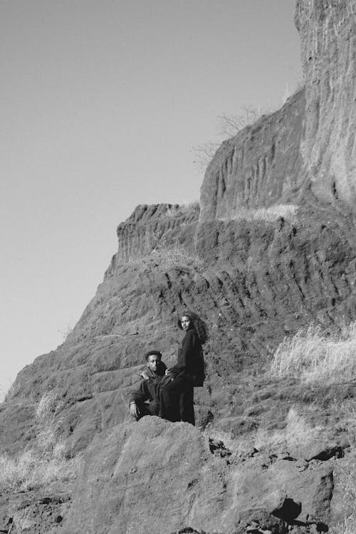 Man and Woman Posing in Hooded Sweatshirts Posing on Rocks