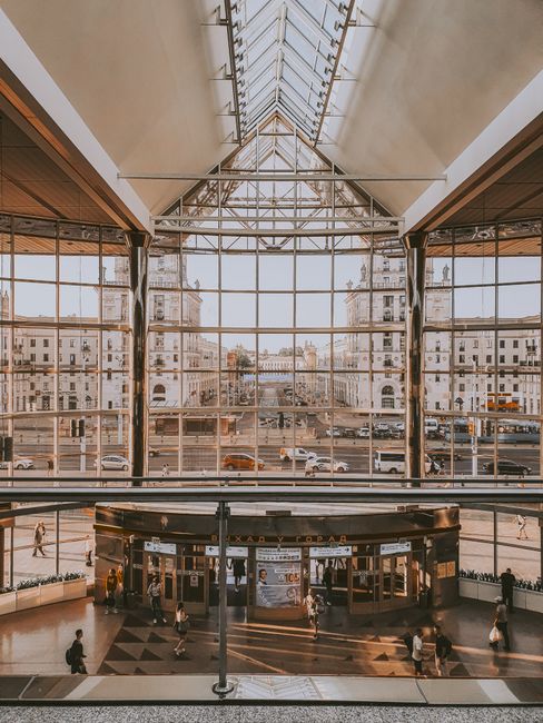 Contemporary railway station with large glass facade highlighting the urban cityscape.