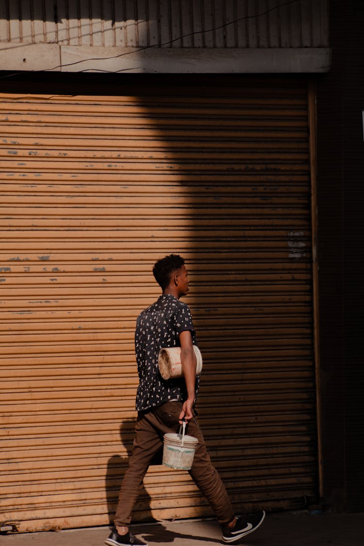 Pedestrian Carrying Bucket Of Paint