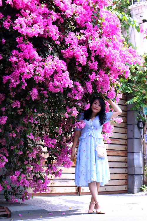 Woman Posing under Purple Flowers