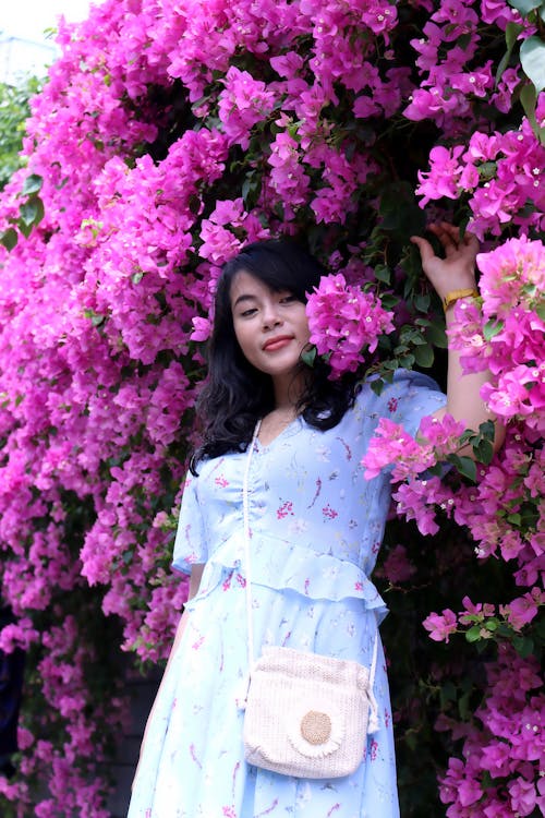 Woman in Dress Posing under Purple Flowers