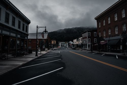 Free Empty town street with historic buildings and moody clouds. Perfect for travel or urban exploration themes. Stock Photo