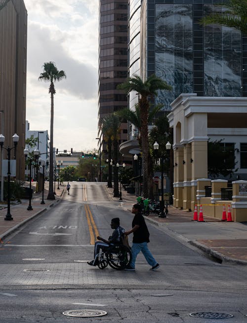 Foto profissional grátis de andando, cadeira de rodas, cidade