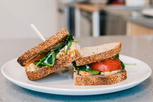 Free A healthy chicken sandwich with tomato and greens on a white plate. Stock Photo