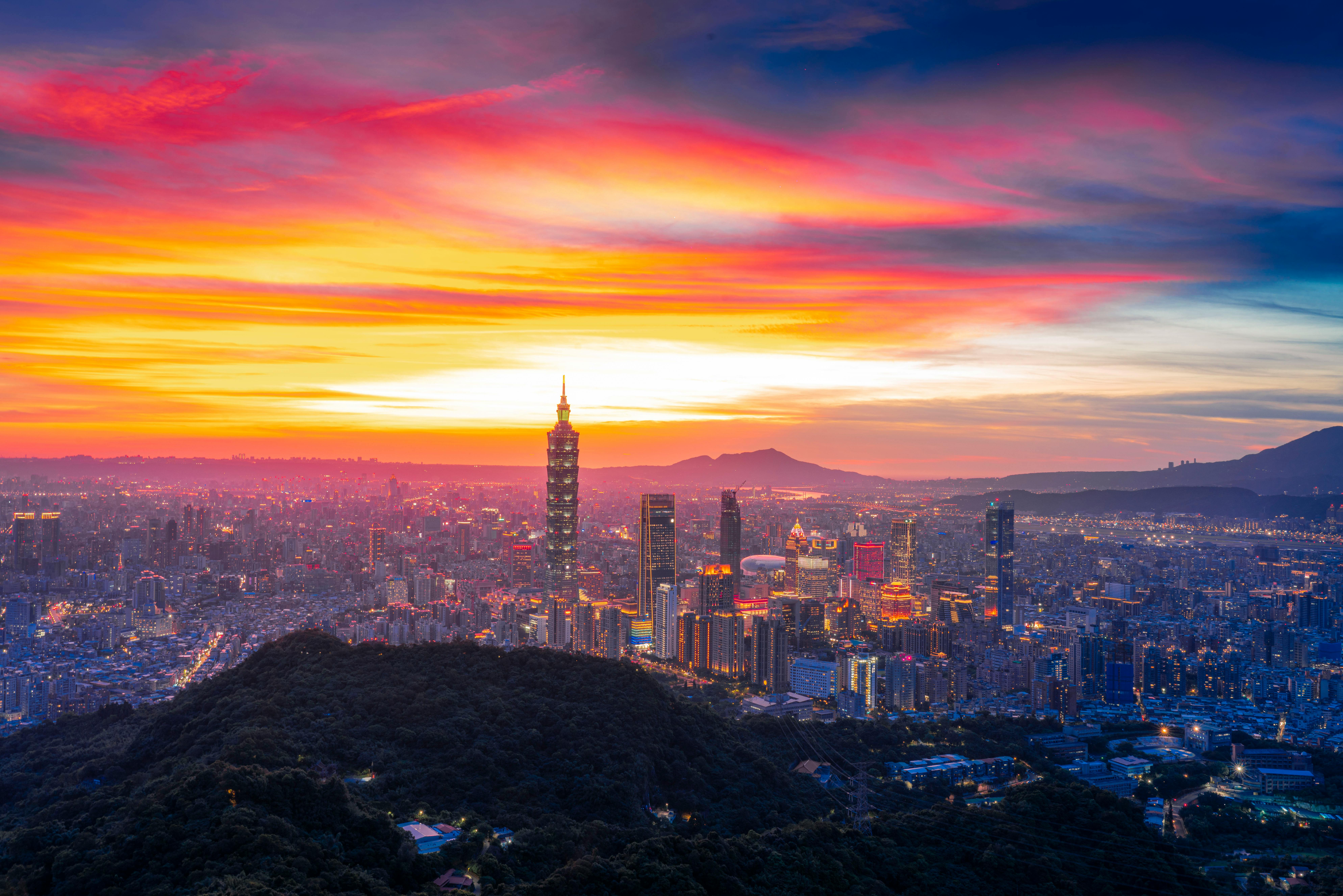 Vibrant sunset view of Taipei skyline with iconic Taipei 101 and colorful sky.