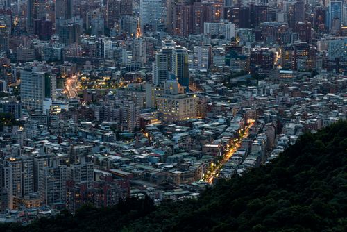 Free Panoramic view of a densely populated cityscape illuminated at dusk. Stock Photo